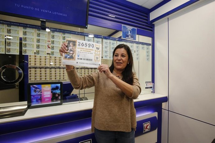 La responsable de la Administración de Lotería del Centro Comercial Carrefour de Salamanca, Mercedes Micó, muestra una imagen el décimo premiado con el 'Gordo'.