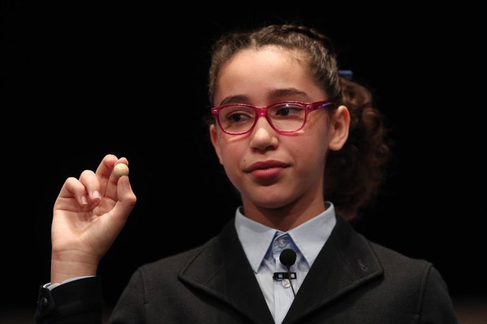Una de las niñas de la residencia de San Ildefonso, Noura Akrouh , posa con la bola del número premiado con el Primer Premio de la Lotería de Navidad, el Gordo de la Lotería, el n  26.590