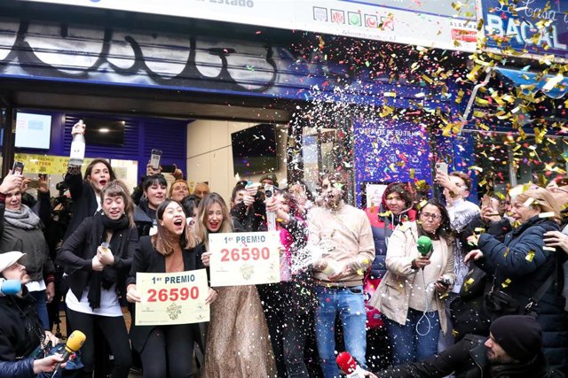 Agraciados por el Premio Gordo del Sorteo Extraordinario de Lotería de Navidad 2019 posan con el número premiado, el  26590, en la famosa administración de 'Doña Manolita.