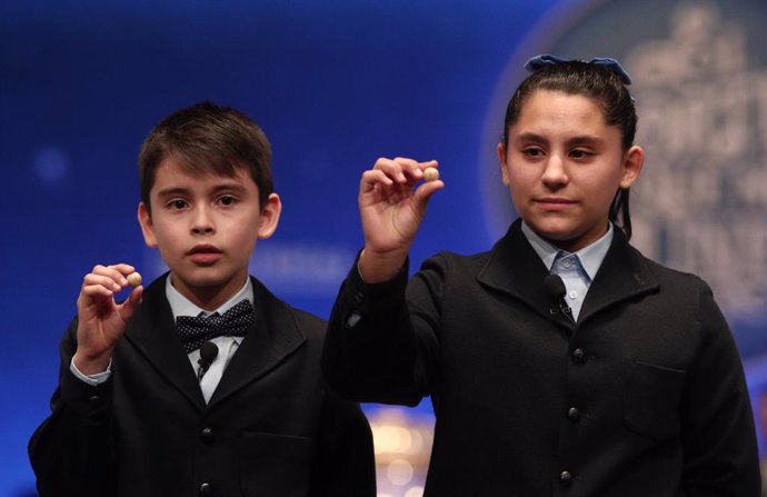 Dos dels nens de la residncia de Sant Ildefons, posen les boles corresponents al segon premi de la loteria de Nadal, amb el núm. 10989, que ha sortit durant la sisena taula del sorteig extraordinari de la loteria de Nadal 2019
