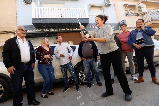 La dueña de Obrador de Luz, Luz María Laveda, descorcha una botella de cava junto con más agraciados con el 'Gordo' de Navidad en Las Torres de Cotillas