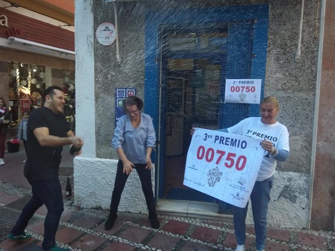 Imagen de la celebración en el exterior de la Administración de Lotería número 1 de Almuñécar (Granada), que ha vendido diez series del 705, tercer premio.