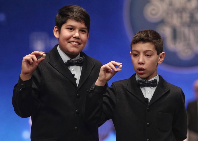 Dos de los niños de la residencia de San Ildefonso, posan con las últimas bolas premiadas en el Sorteo Extraordinario de la Lotería de Navidad 2019 en el Teatro Real de Madrid (España), a 22 de diciembre de 2019.