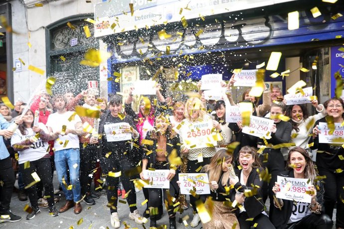 Algunos de los agraciados con distintos premios de la Lotería, frente a la famosa administración de 'Doña Manolita', donde se han tocado algunos de los premios del Sorteo Extraordinario de la Lotería de Navidad 2019