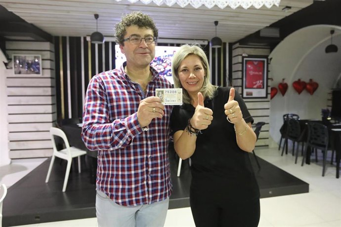 Los dueños de un bar agraciado de uno de los quintos premios, José Manuel Ambrosio y  Ana Basile posan con el número 75.206, en el bar Segunda Avenida , en Teruel