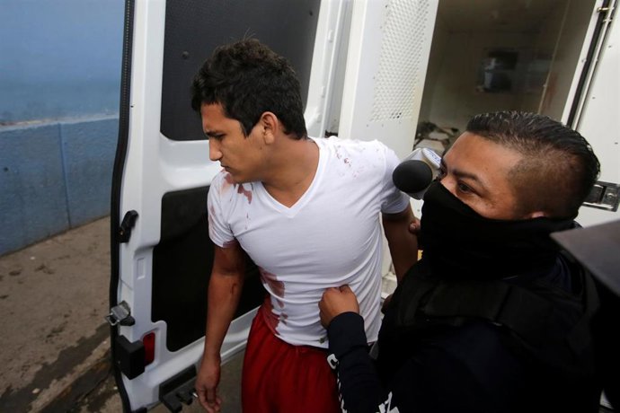 La policía escolta a un herido tras una reyerta en una cárcel de Honduras