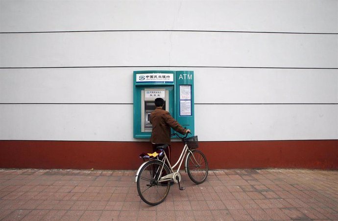 Un hombre se acerca a un cajero automático en la ciudad de Pekín, China