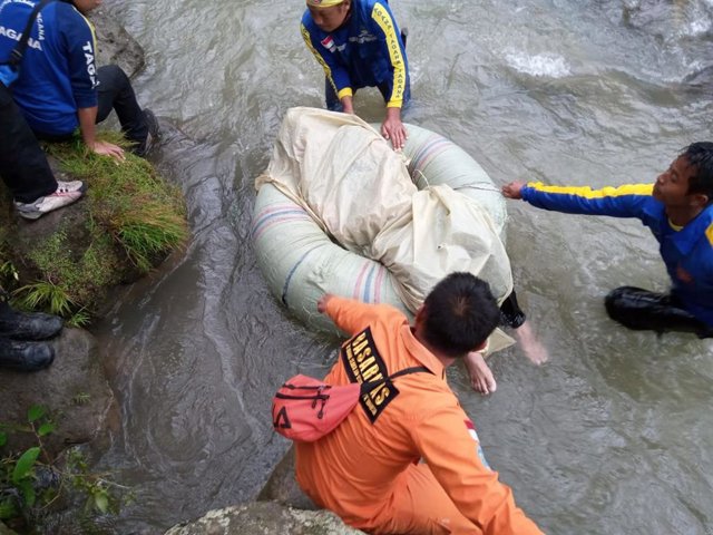 Trabajadores realizan labores de rescate para recuperar los cuerpos de las víctimas del autobús que cayó por un barranco en Sumatra, Indonesia.