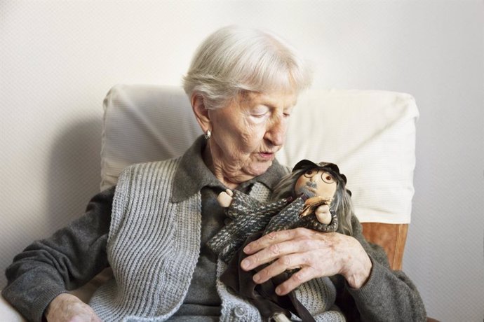 Mujer mayor con un muñeco.