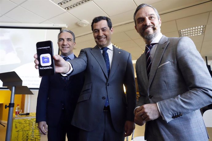 El presidente de la Junta de Andalucía, Juanma Moreno (c)  junto a los consejeros Elías Bendodo (1i) y Juan Bravo (1d) en la  presentación de la app 'Carpeta Ciudadana' en Málaga a 11 de diciembre del 2019
