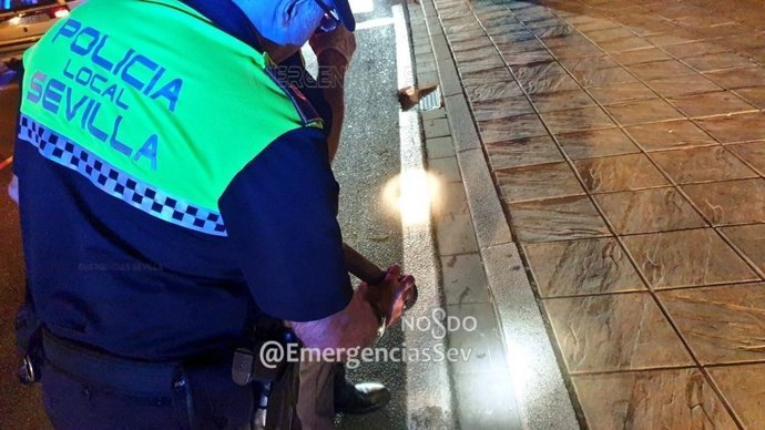 Un policía local de Sevilla actúa ante un siniestro en la calle