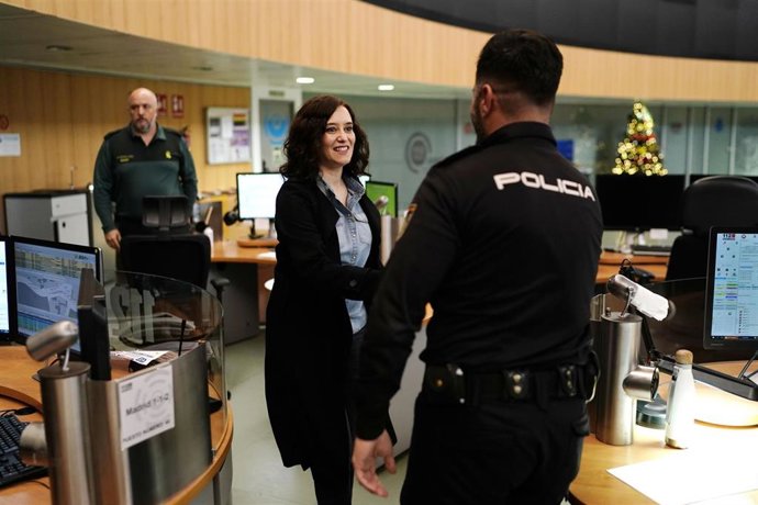 La presidenta de la Comunidad de Madrid, Isabel Díaz Ayuso, saluda a un policía nacional de guardia durante Nochebuena para felicitarle la Navidad.