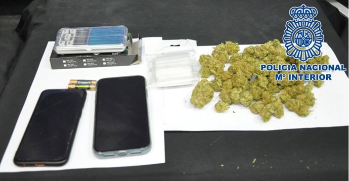 Los cogollos de marihuana, los móviles y la balanza de precision y las bolsitas incautadas a los detenidos.