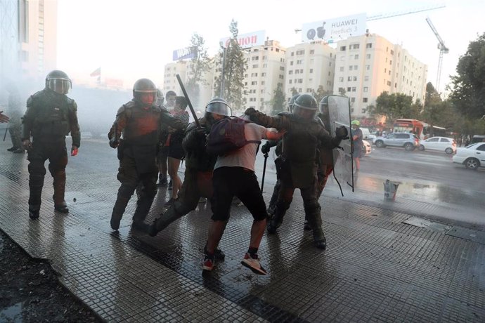 Un manifestante es reducido por agentes del Cuerpo de Carabineros durante una de las protestas contra el Gobierno de Sebastián Piñera en Santiago (Chile).