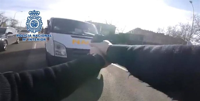 Imagen de un agente de Policía Nacional empuñando su arma para detener a un ladrón de una furgoneta tras una persecución de 45 minutos.