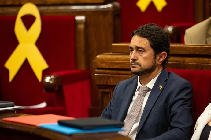 El conseller de Territorio y Sostenibilidad en el gobierno de Cataluña, Dami Calvet,  junto a un lazo amarillo, en el debate sobre política general, en el Parlament de Catalunya, en Barcelona, a 25 de septiembre de 2019.