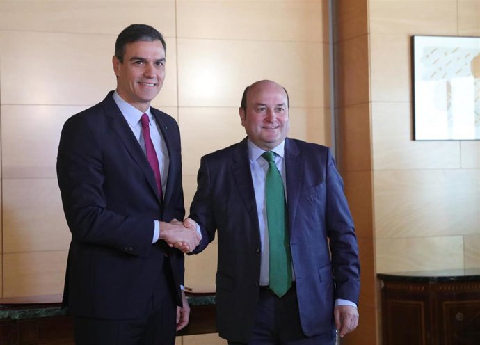 El presidente del Gobierno en funciones, Pedro Sánchez (izq) y el presidente del EBB del PNV, Andoni Ortuzar (dech), se dan la mano tras firmar el acuerdo entre el PSOE y el PNV para la investidura de Pedro Sánchez