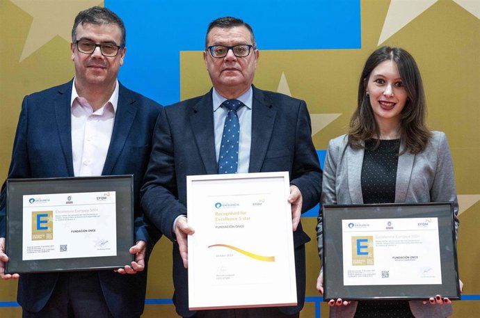 José Luis Martínez Donoso y dos trabajadores de Fundación ONCE sujetan el Sello de Excelencia 'EFQM 500+'