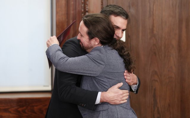Pedro Sánchez y Pablo Iglesias (dech), se dan un abrazo  durante el acto de presentación del programa de Gobierno del PSOE y Unidas Podemos, en el Congreso. 