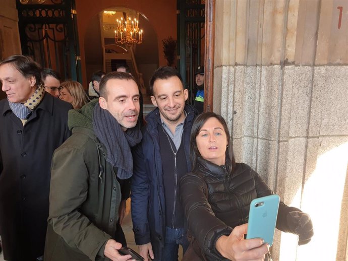 Alejandro Amenábar (centro) con dos aficionados al cine a la puerta del Ayuntamiento de Salamanca