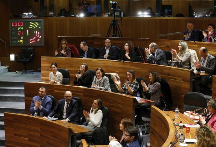 Bancada socialista, con el presidente del Principado, Adrián Barbón, en un extremo de la imagen, aplaudiendo tras la votación que permitió aprobar la ley presupuestaria para 2020 en la Junta General.