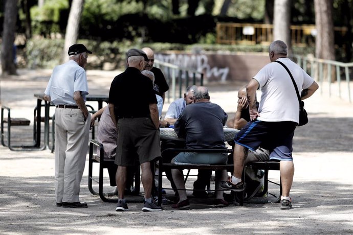 Diversos pensionistes juguen al dmino en un parc de Madrid.