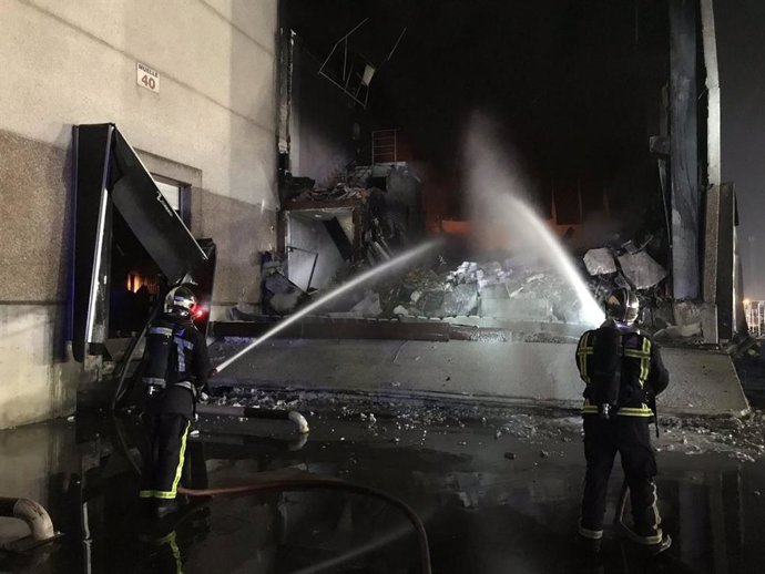 Dos bomberos intentan controlar un fuego en una nave en el sur de la Comunidad de Madrid.