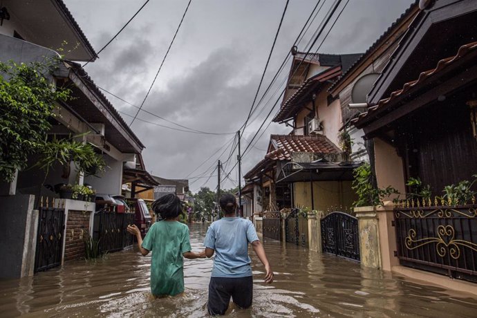 Dues dones caminen a través d'un carrer inundat després de les intenses pluges que han caigut a la capital d'Indonsia.