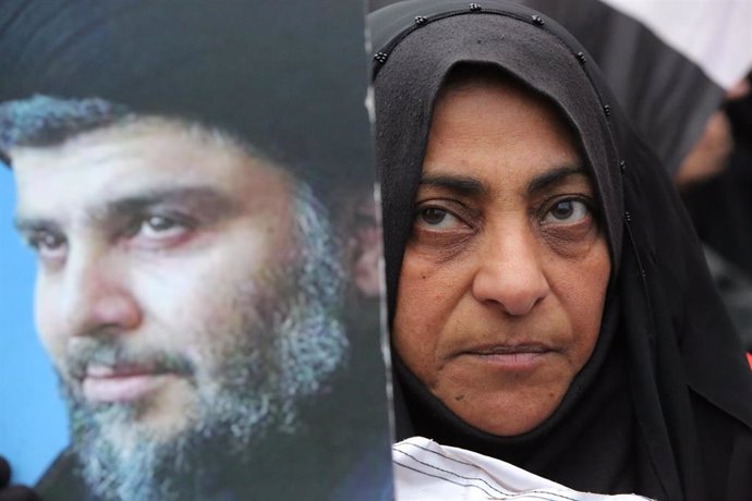 Una mujer con un retrato del clérigo chií Muqtada al Sadr