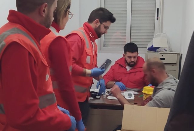 Voluntarios de Cruz Roja atienden a uno de los ocho inmigrantes rescatados esta pasada madrugada.