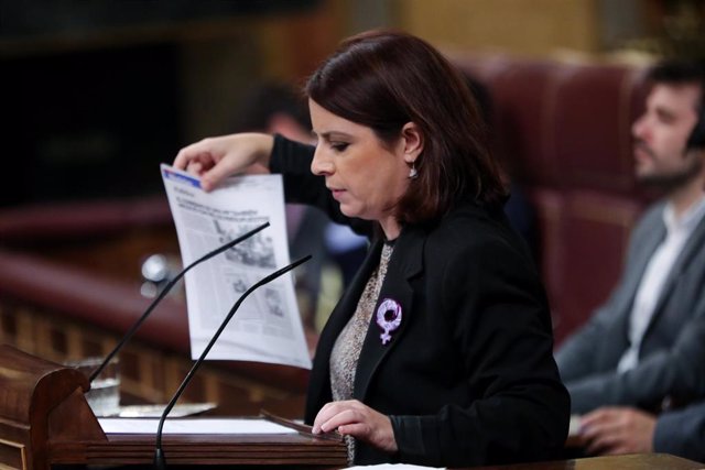 La portavoz del PSOE en el Congreso, Adriana Lastra, muestra una foto de miembros del PP y UPN negociando presupuestos con nacionalistas vascos en 1993, en la segunda sesión del debate de investidura del candidato socialista a la Presidencia de Gobierno