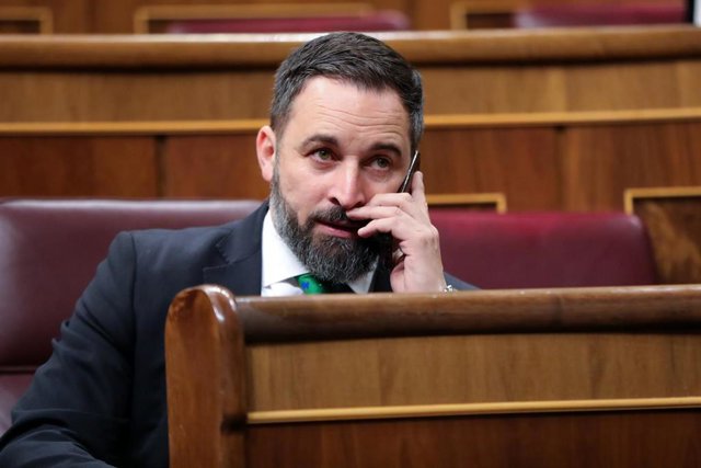El presidente de VOX, Santiago Abascal, habla por teléfono desde su escaño momentos antes de comenzar la segunda sesión del debate de investidura del candidato socialista a la Presidencia de Gobierno en la XIV Legislatura en Madrid (España).