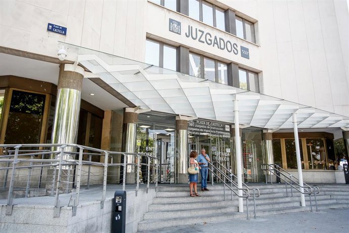 Personas entran por la puerta de los Juzgados de Instrucción ubicados en la Plaza de Castilla de Madrid.