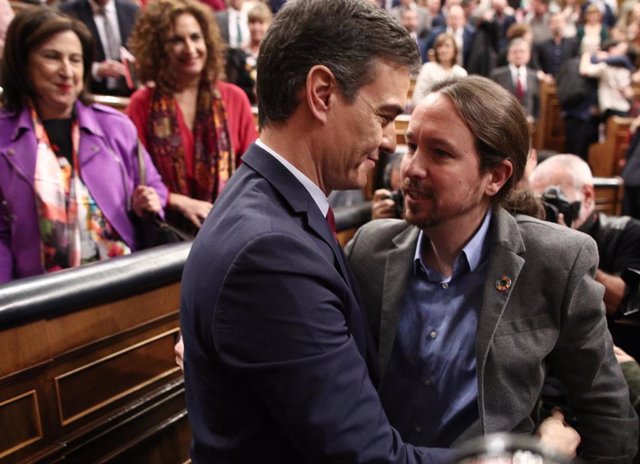 El secrretario general de Podemos, Pablo Iglesias, felicita al al presidente del Gobierno, Pedro Sánchez, tras ser elegido al finalizar la segunda sesión de votación para la investidura del candidato socialista a la Presidencia del Gobierno