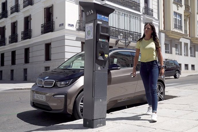 Una mujer con su coche eléctrico