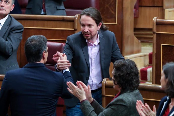 El secretario general de Podemos, Pablo Iglesias, estrecha la mano del presidente del Gobierno en funciones, Pedro Sánchez, tras su intervención en la primera sesión del debate de investidura de Sánchez.