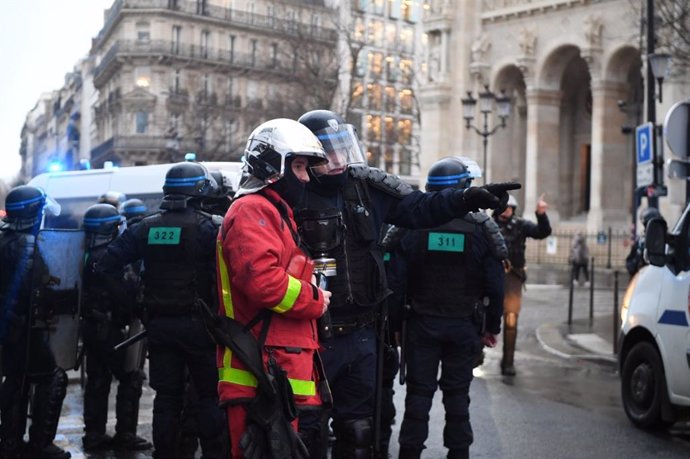 Un bombero junto a agentes de la Policía en París durante las manifestaciones contra la reforma de las pensiones.