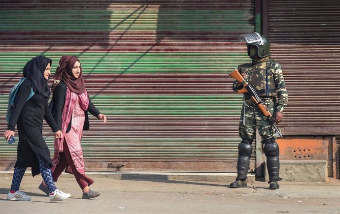 Dos mujeres pasan ante un militar del Ejército de la India en la región de Cachemira.