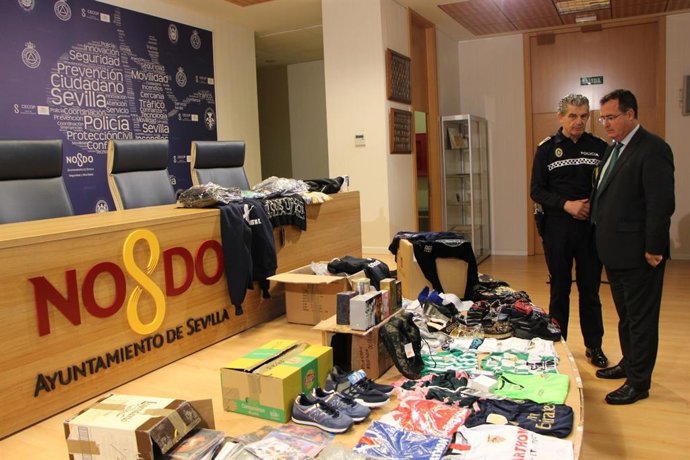 El delegado de Gobernación de Sevilla, Juan Carlos Cabrera, con los objetos falsificados incuatados por la Policía Local