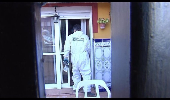 Un agente entra en la vivienda incendiada de Castilleja de la Cuesta (Sevilla)