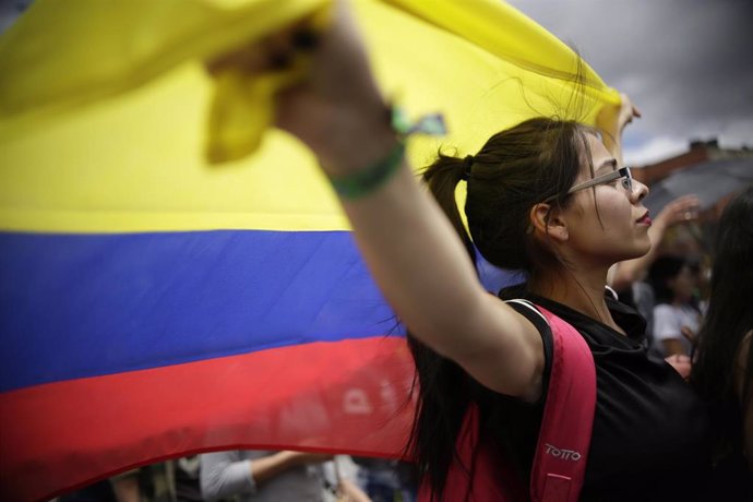Una manifestante con la bandera de Colombia