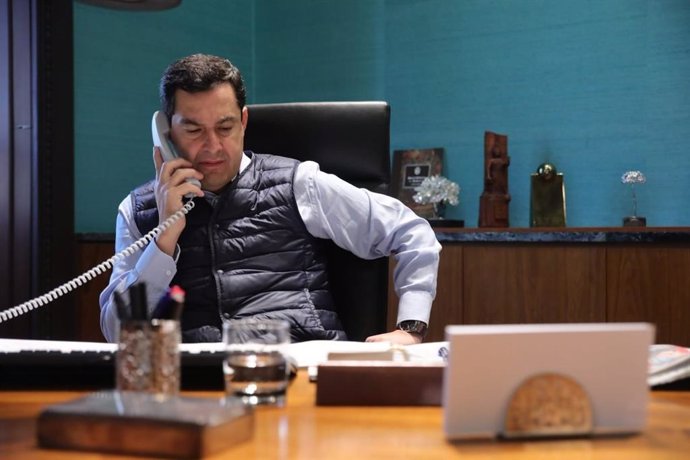 El presidente de la Junta, Juanma Moreno, al teléfono con el presidente del Gobierno en funciones, Pedro Sánchez. En una imagen de archivo.
