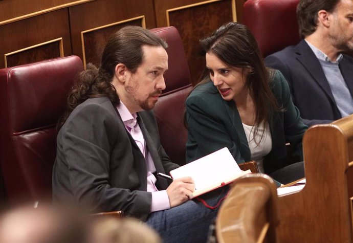 El secretario general de Podemos, Pablo Iglesias, y la portavoz parlamentaria de Unidas Podemos, Irene Montero, hablan en sus escaños en el Congreso de los Diputados durante la primera sesión del debate de investidura del candidato socialista a la Presi