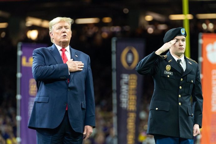 El presidente de Estados Unidos, Donald Trump, canta el himno durante un partido de fútbol americano de la Liga Universitaria en Nueva Orleans.