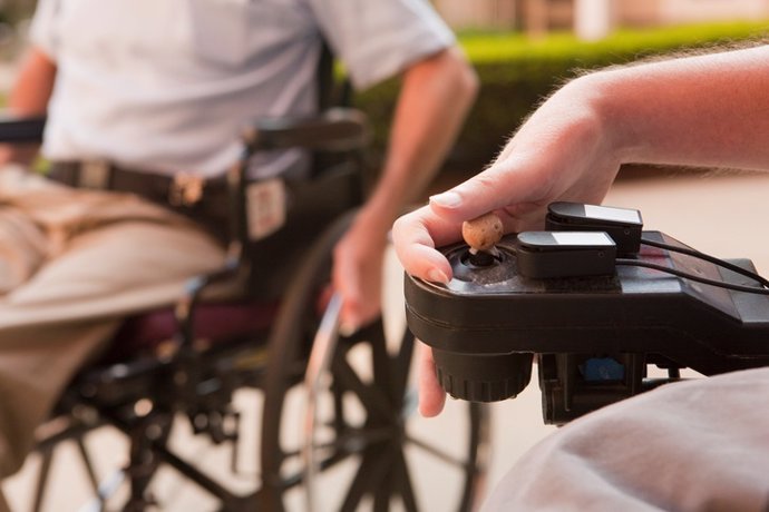Man with Duchenne muscular dystrophy controlling a motorized wheelchair with degenerated hands