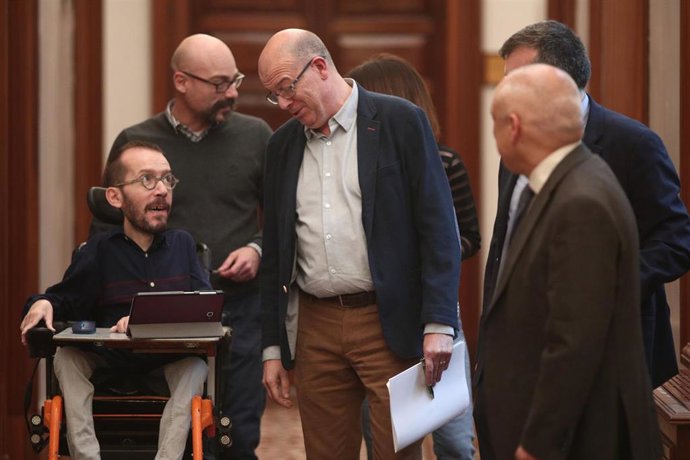 El portavoz de Unidas Podemos en el Congreso, Pablo Echenique (izq) habla con el diputado del PSOE en el Congreso, José Zaragoza (3i), a la salida de la Junta de Portavoces del Congreso de los Diputados, en Madrid (España), a 15 de enero de 2020.