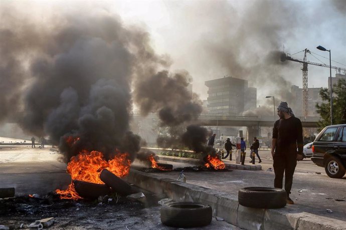 Manifestantes queman neumáticos para intentar bloquear una carretera en Líbano en el marco de las protestas contra la crisis política y económica
