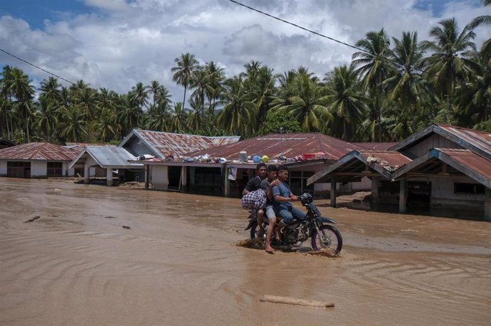 Un hombre conduce su motocicleta a través del lodo tras las fuertes lluvias que provocaron inundaciones en la provincia de Bengkulu, en la isla indonesia de Sumatra, en abril de 2019.