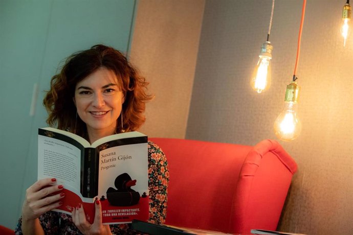 La escritora Susana Martín Gijón posa con su novela 'Progenie', tras una entrevista para Europa Press en la sede de Random House en Madrid (España).