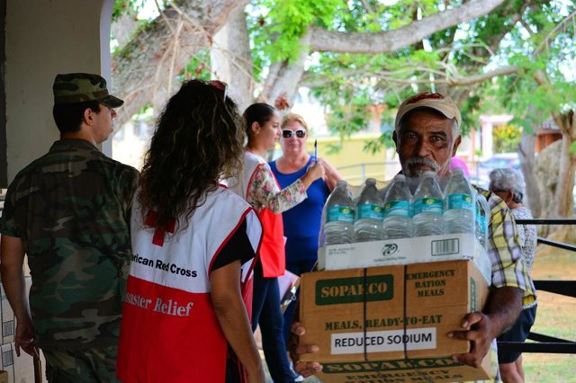 Un hombre recibe ayuda humanitaria por parte de la Cruz Roja tras el paso del huracán María por Puerto Rico en 2017.